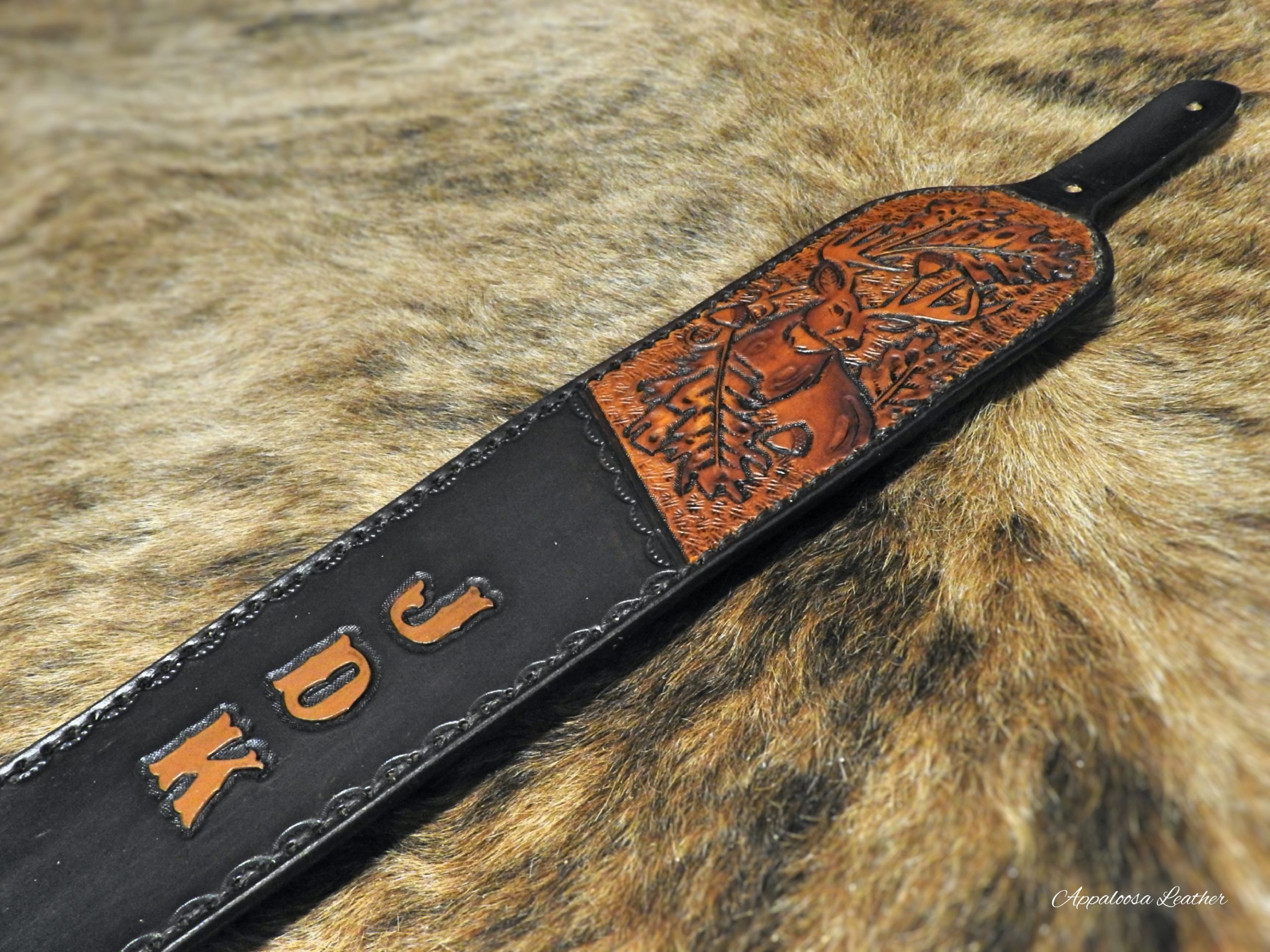 custom leather rifle sling with a whitetail deer, oak leaves and acorn with custom lettering on a dark background